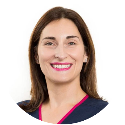 A professional headshot of Dr. Angela Gaffey, with a warm smile, wearing a navy blue top with a pink detail.